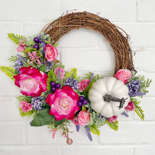 Pink and purple autumn flower door wreath with a large white pumpkin 